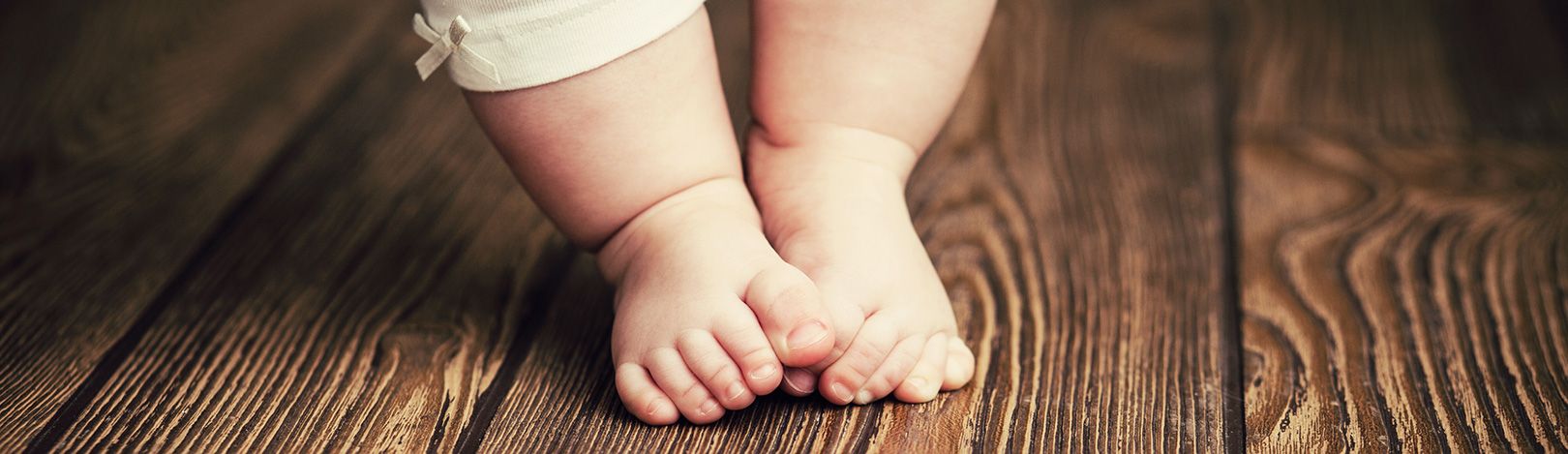 Babyfüße auf einem Holzboden